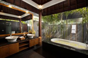 a bathroom with two sinks and a bath tub at Villa Ambara Bali by Nakula in Canggu
