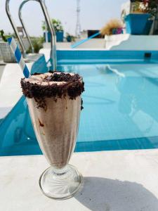 een chocolademilkshake in een glas naast een zwembad bij Moustache Hostel, Jaipur in Jaipur