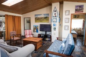 a living room filled with furniture and a tv at Artists cottage in Ladybrand