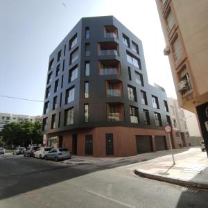 een hoog gebouw met auto's ervoor geparkeerd bij Elite Beach in Málaga +6 foto's