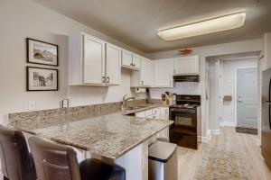 a kitchen with white cabinets and a granite counter top at First Tracks 3105 condo in Steamboat Springs +20 photos