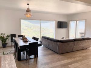 a living room with a large couch and a table at villa I Cresti proche centre ville et plages in Ajaccio