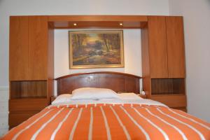 a bed in a room with a painting on the wall at Mountain View Rooms in Kindsbach