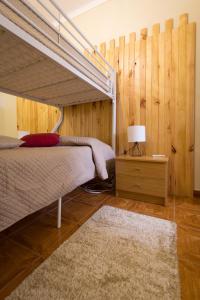een slaapkamer met een bed en een houten muur bij Beja Hostel in Beja