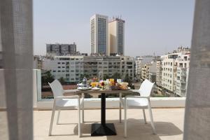 a table with a plate of food on a balcony at Mid Town Hotel Casablanca in Casablanca