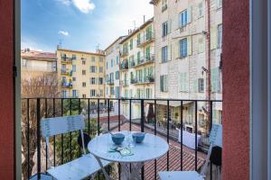 a balcony with a table and chairs and buildings at L'Abeille - Boutique Apartments in Nice