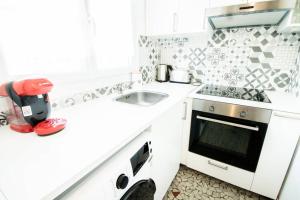 cocina blanca con fregadero y fogones en Ideal acces aux portes de Paris, en Cachan