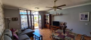 a living room with a couch and a ceiling fan at Casa Aitana in Puerto Calero