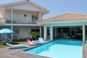 a villa with a swimming pool and a house at Aresia in Arès