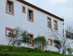 LiebstadtにあるFerienwohnung Klügerの茶色の窓が横に広がる白い家
