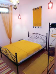 ein Schlafzimmer mit einem Bett mit einer gelben Decke in der Unterkunft Lazy Lizard by the Ocean in Seixal