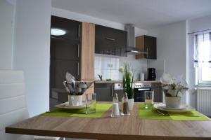 una cocina con una mesa de madera con platos y vasos. en Ferienwohnung Klüger, en Liebstadt