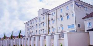 阿奴古Residency Hotels Enugu Independence Layout的一座带栅栏的大型白色建筑