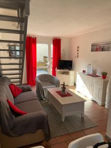 a living room with a couch and a table at Charmante maison au coeur de la pinède Classée 3 étoiles in Lacanau