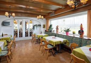 a restaurant with tables and chairs in a room at Gasthof Mesnerwirt in Auna di Sopra