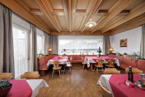 un restaurant avec des tables et des chaises et une grande fenêtre dans l'établissement Gasthof Mesnerwirt, à Auna di Sopra