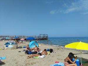 un gruppo di persone sdraiate su una spiaggia con ombrelloni di Bed & Diner Les Terrasses de La Palme a Lapalme