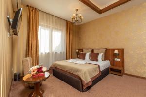 a hotel room with a bed and a table at Hotel Gott in Braşov