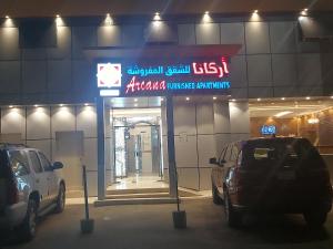 two cars parked in front of a car dealership at أركانا للشقق المخدومة in Tabuk