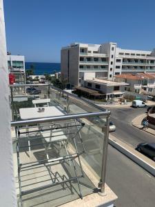 einen Balkon mit einem Tisch und Stadtblick in der Unterkunft One-bedroom beach apartment, 30m from the best beach in Protaras