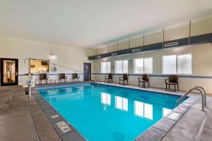 Comfort Inn & Suites Ponca City near Marland Mansion في Ponca City: مسبح كبير مع كراسي وطاولات