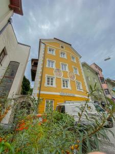 żółty budynek z zegarami na boku w obiekcie Blackhome Vintage Innsbruck City Centre I contactless check-in w mieście Innsbruck