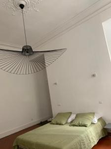 - une chambre avec un lit et un grand ventilateur dans l'établissement Liberté, à Marseille
