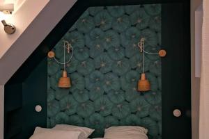 a bedroom with a green wall with two beds at La Dilettante, petite maison rénovée, avec jardin in Vertaizon
