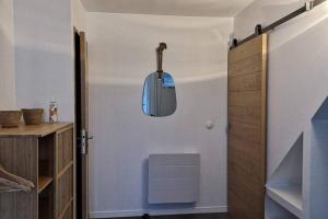 a room with a hallway with a door and a light fixture at La Dilettante, petite maison rénovée, avec jardin in Vertaizon