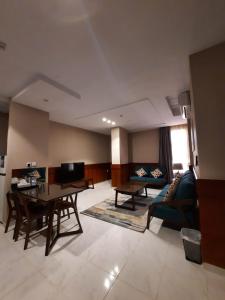 - un salon avec un canapé et une table dans l'établissement Biz Hotel Apartments, à Tabuk