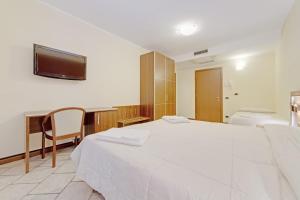 a bedroom with a large white bed and a desk at Hotel Grotto Bagat in Lavena Ponte Tresa +37 photos