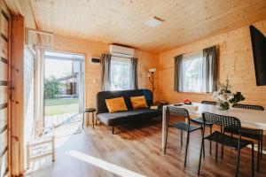 a living room with a couch and a table at Domki letniskowe Babie Doły in Gdynia