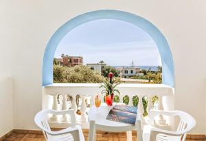 d'une table et de chaises blanches sur un balcon avec fenêtre. dans l'établissement Hotel Galidon Wellness Park & SPA, à Ischia