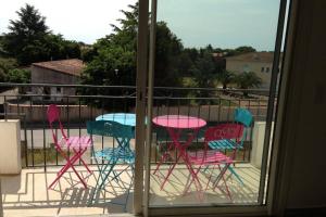 吉索納恰的住宿－Ghisonaccia, F4 de charme，阳台上配有三把五彩缤纷的椅子和一张桌子