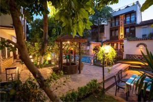 a patio with a table and chairs in front of a building at Castle Old Town Hotel in Antalya