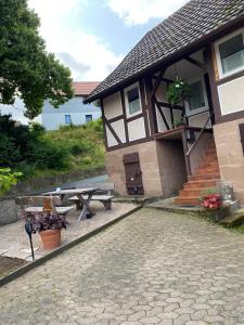 a building with a picnic table and a bench at Haus Lindenteichblick in Atzenhausen