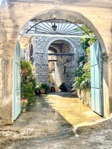 un arco con entrada a un edificio de piedra en Kubeja Guest House, en Gjirokastra