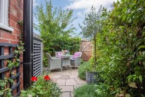 a patio with a table and chairs in a garden at Charlie's Cottage in Ludlow