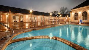 a swimming pool at night with lights on at Bestway Inn in Kaufman