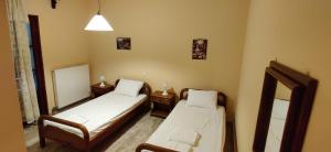 a small room with two beds and a mirror at Elena's Apartments Corfu in Ipsos