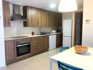 a kitchen with wooden cabinets and a table with chairs at Duplex RIO EBRO in Deltebre