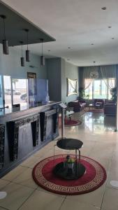 a lobby with a bar and a chair in a room at Hotel La Corniche Fnideq in Fnidek