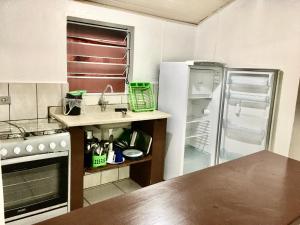 a kitchen with a sink and a refrigerator at Chalés Damata in Ubatuba
