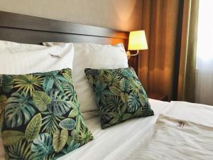 una cama con dos almohadas encima en Hotel & Browar Słociak, en Opole 23 fotos más