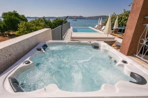 a jacuzzi tub on a patio next to a pool at Apartments Sea in Trogir