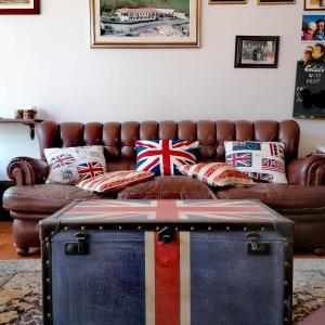 sala de estar con sofá de cuero marrón con almohadas en B&B Il Santo Pellegrino, en Adrara San Rocco