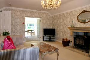 a living room with a fireplace and a television at Thistleyhaugh farmhouse in Longhorsley