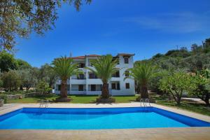 a villa with a swimming pool and palm trees at Villa Maro in Skopelos Town