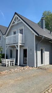 a house with a porch with a table and a balcony at Ferienhaus Ilsebil mit Sauna - in Gager in Gager