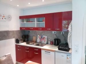 a kitchen with red cabinets and a sink at Ferienwohnung Tannenwald in Bad Wildbad